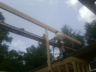 Carpenter setting a ridge beam over a new addition frame — Ice Dam Removal by Roofing Brothers in Wooster