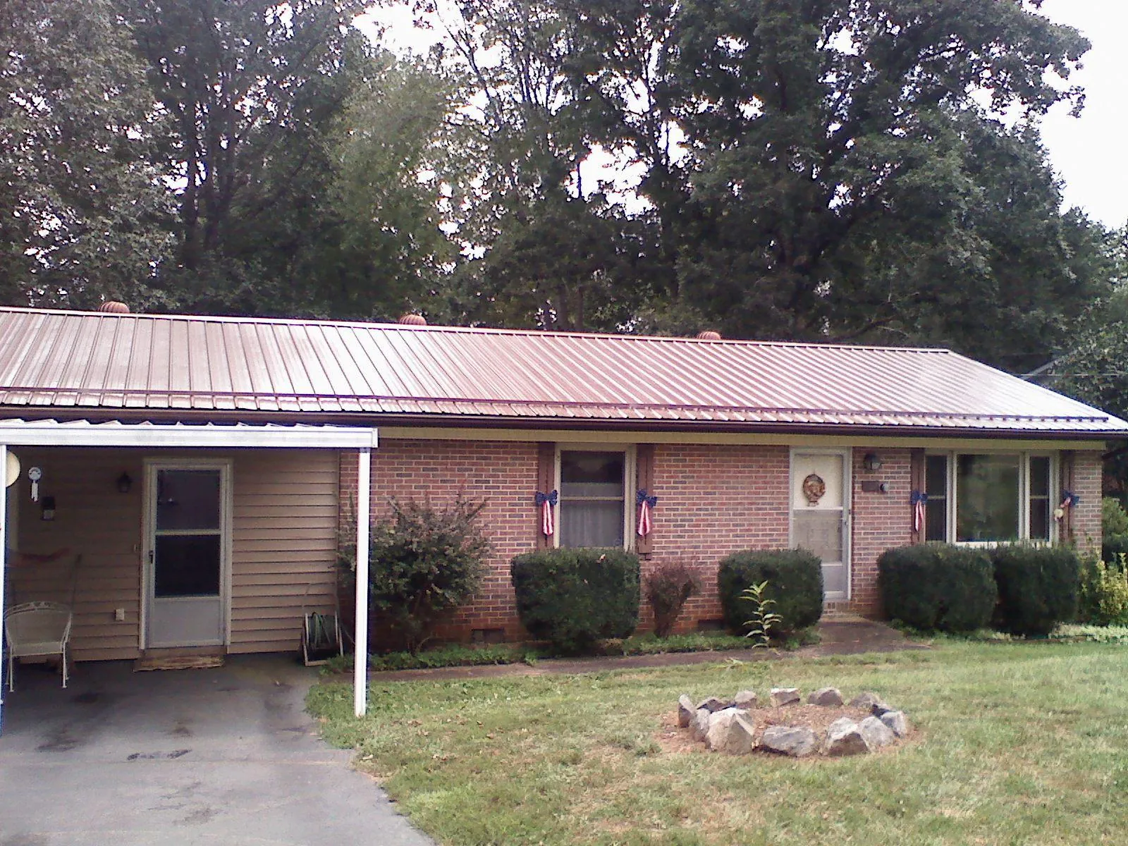 Bronze metal roof and carport on a brick ranch home — Roof Repair work by our crew in Wooster