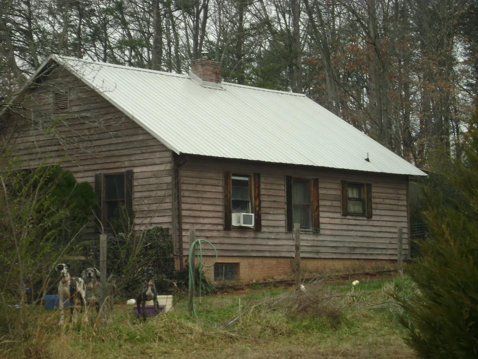 White metal roof on an old wood sided farmhouse, from a Metal Roof Installation job in Wooster